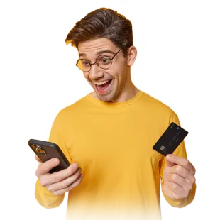 Young man looking at phone and holding credit card, elated